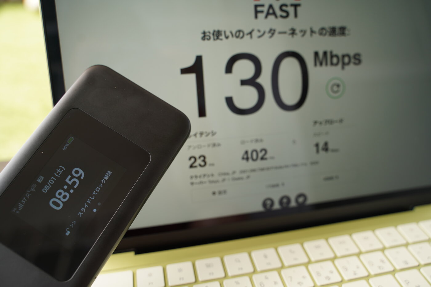 GMOとくとくBB WiMAXの実測速度。5Gエリア内でMacBookに接続し、下り130Mbpsを記録した測定画面とWiMAX端末